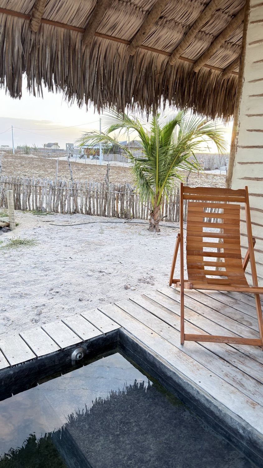 Deck de madeira com piscina de imersão e cadeira de praia